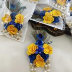 Decorative brooch with a peacock feather, blue flowers and peral chain ideal for wedding favors and coat accessories.