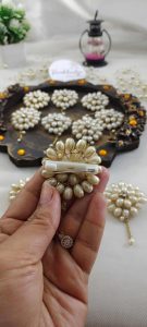 A pair of elegant pearl brooches with intricate floral designs, featuring a cluster of pearl petals and a central rhinestone, perfect for wedding attire accessories, nikah ceremonies, and traditional wedding outfits