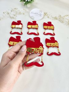 acrylic Baarati brooches with a red and gold design, ideal for groom side brooches and wedding attire accessories at Indian and Nikah weddings