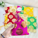 issue potlis in red, yellow, green, and cream, adorned with gold patterns, suitable for wedding and anniversary gifts