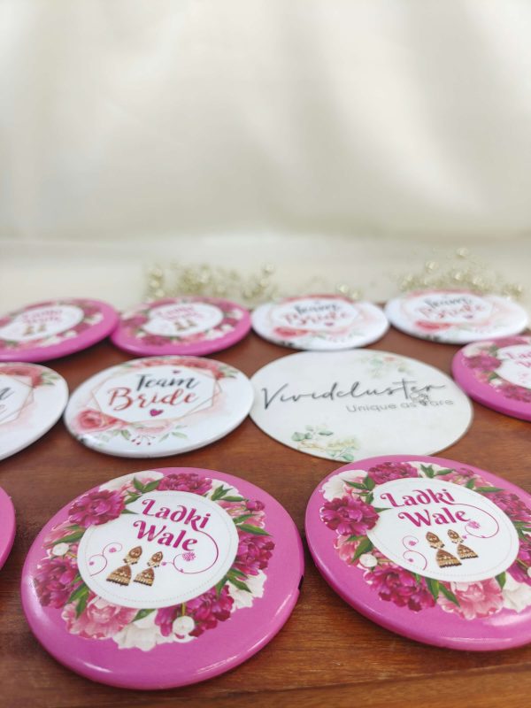 a pink and white ladkiwale brooch featuring the text Ladki Wale brooch with a floral print accessory for bride's side members during wedding ceremonies, baraat day, or nikah events