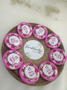 A pink and white brooch eaturing "Ladki Wale" text with a floral design nikah ceremonies, or as memorable wedding favors