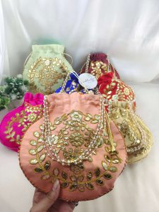 Beautifully crafted Gota Potlis with intricate gold embroidery and pearl handles, ideal for wedding favors and bridesmaid gifts.