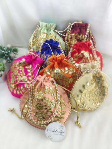 ornate Gota Potlis with detailed gold embroidery and pearl handles, perfect for bridal accessories and giveaway favors