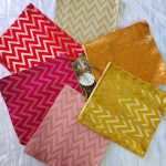 Lehariya printed bags in bright yellow, orange, and pink colors, adorned with zigzag patterns. These stylish bags, perfect for weddings and nikah ceremonies, can serve as wedding favors, gift hampers
