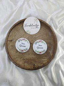 a round brooch with "Team Groom" text and floral decorations. suitable for groomsmen at weddings and nikah ceremonies, serving as a charming addition to their wedding attire