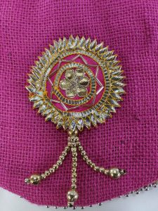 A handcrafted pink jute potli bag with detailed golden Gota embellishments and a decorative handle, perfect for wedding giveaways and nikah ceremonies.