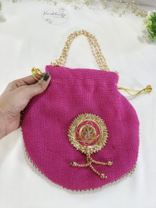 pink potli bag made from jute, adorned with golden Gota work and a braided handle, suitable for wedding gifts, nikah ceremonies, and bridesmaids' favors.