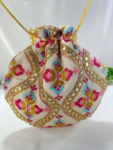 potli bag with detailed embroidery in vibrant colors and golden decorations. The bag is tied with a golden drawstring and is perfect for weddings, nikah ceremonies,