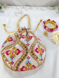 beautifully crafted potli bag with intricate embroidery featuring colorful flowers and shimmering gold accents erfect for use as a wedding favor, nikah ceremony gift, or bridesmaid's present.