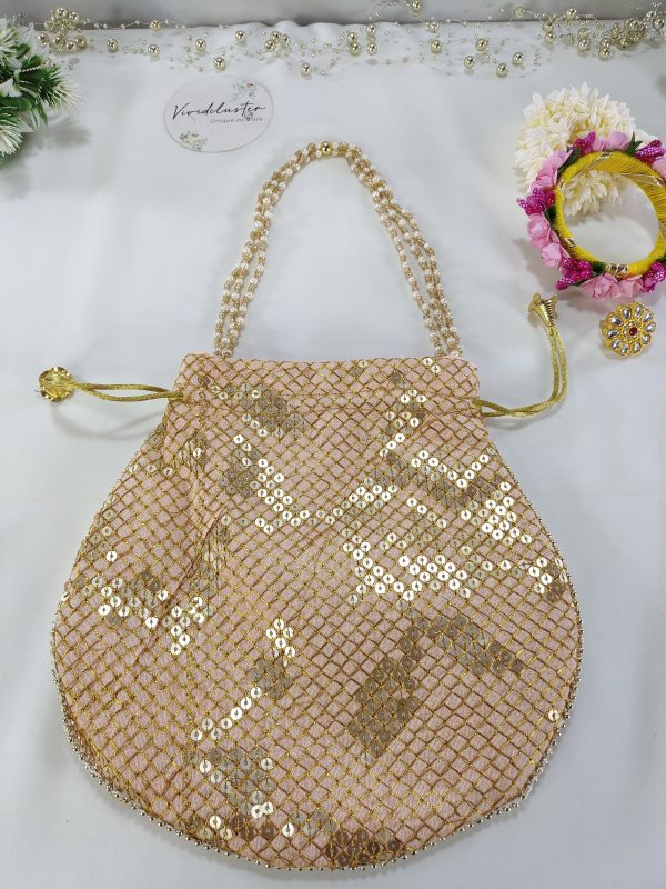 A refined Sippy Gota Potli with a golden lattice of sequins on blush pink fabric. This elegant potli is ideal for weddings, bridal showers, and nikah ceremonies, serving as a beautiful wedding favor or giveaway for bridesmaids