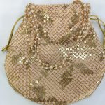 A beautifully crafted Sippy Gota Potli, adorned with intricate gold sequins in a delicate mesh pattern on a light pink fabric, perfect for wedding ceremonies, nikah events, and bridal gift hampers. The potli features a drawstring closure with golden cords and is ideal for use as a bridesmaid favor or wedding giveaway