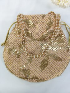 A beautifully crafted Sippy Gota Potli, adorned with intricate gold sequins in a delicate mesh pattern on a light pink fabric, perfect for wedding ceremonies, nikah events, and bridal gift hampers. The potli features a drawstring closure with golden cords and is ideal for use as a bridesmaid favor or wedding giveaway