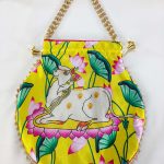 Drawstring potli bag showcasing a tranquil cow motif amidst a colorful floral backdrop, ideal for wedding favors and bridesmaids gifts