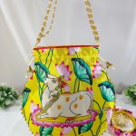 drawstring potli bag with a delightful cow illustration, set against a vivid yellow canvas with pink and green floral elements