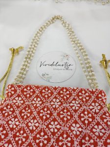 Embroidered Wedding Potli in vibrant red, featuring detailed white designs, perfect for a bride’s wedding accessories, nikah ceremony gifts, or wedding favors for bridesmaids.