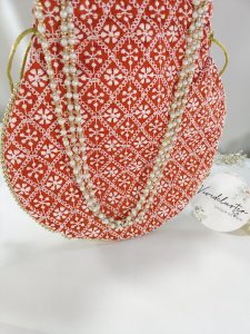 Red Embroidery Potli with delicate white designs, ideal for use as a wedding favor, bridesmaid gift, or accessory for a nikah ceremony