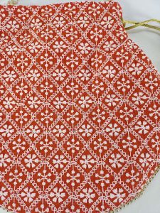 Classic red Embroidery Wedding Potli with white patterns, suitable for use as a wedding favor, bridesmaid gift, or bride's accessory