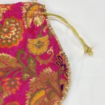 pink potli bag decorated with gold embroidery and finished with a gold drawstring, suitable for bridal use, wedding accessories, and festive gifting