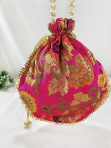 pink potli bag, intricately designed with golden floral embroidery, adorned with a gold drawstring, perfect for wedding favors, nikah ceremonies, and bridesmaid gifts