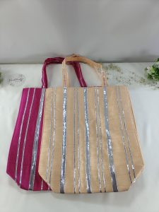 - Featured in this image are stylish potli bags, perfect for a bride’s wedding favors. The bags, available in pink and peach with silver stripes, are ideal for distributing small gifts
