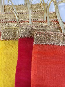 bridal silk potli bags in orange, red, and yellow hues, featuring golden lace handles, ideal for wedding favors, bridal shower gifts, and nikah ceremony giveaways. These handmade potlis are crafted from luxurious silk fabric, making them a perfect wedding accessory for brides and bridesmaids