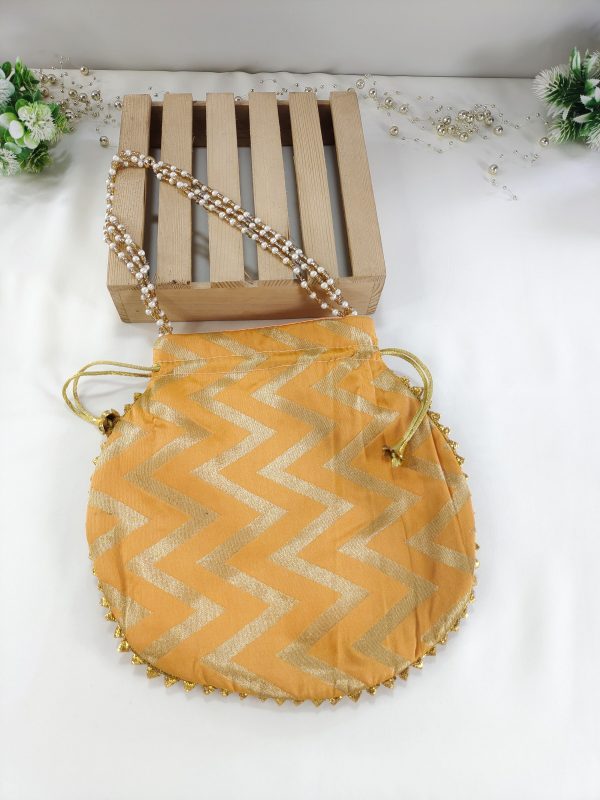 Lehariya printed bags in bright orange adorned with zigzag patterns. These stylish bags, perfect for weddings and nikah ceremonies, can serve as wedding favors, gift hampers