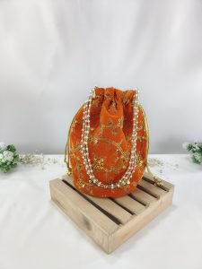 Orange Embroidery Potli Bag with Pearl Handle for Bridal Favors: This striking potli bag, decorated with golden floral embroidery, is perfect for wedding and bridal shower gifts. The vibrant orange fabric is complemented by a pearl handle