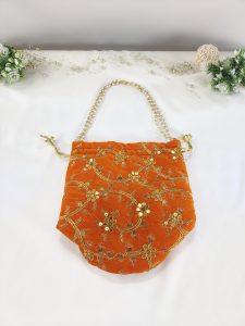 A beautifully crafted potli bag featuring intricate gold embroidery on vibrant orange fabric. This bag is perfect for wedding favors, nikah ceremonies, and bridal showers. Its elegant design makes it an excellent bridesmaid gift