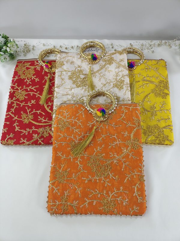 collection of beautifully embroidered wedding potli bags comes in a variety of vibrant colors such as red, white, green, and yellow, with golden floral embroidery and features a stylish golden handle with a colorful tassel, making it a perfect wedding accessory