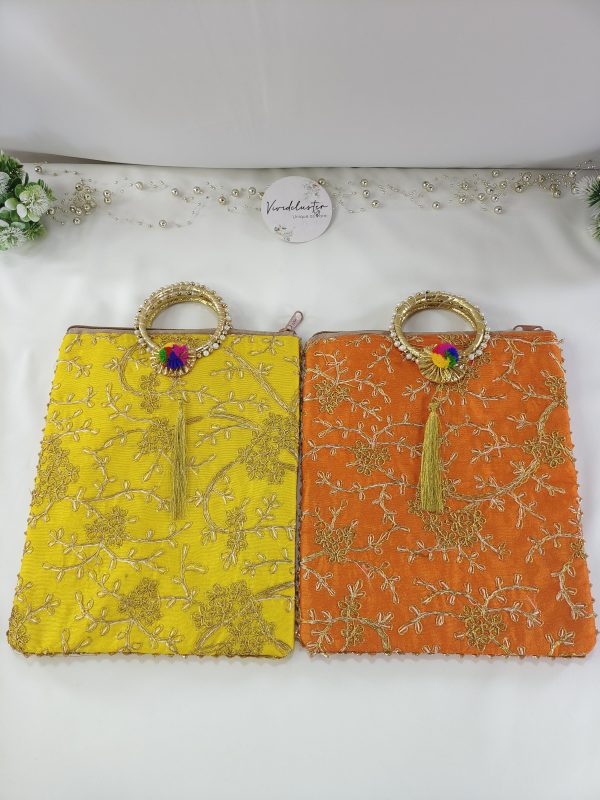 set of embroidered potli bags features a range of vibrant colors that are perfect for any wedding event. The bags are decorated with golden floral embroidery and a matching golden handle with a tassel. Ideal for use as bridal shower gifts, nikah ceremony accessories, or wedding favors