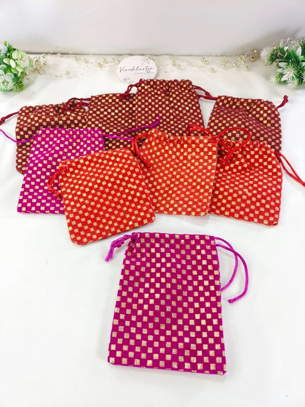 checkered Ginni pouch wedding potli in maroon, red, and magenta shades, adorned with golden threads. Perfect for wedding favors, baraati gifts