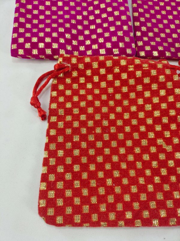 Set of traditional Ginni pouch wedding potlis with intricate golden detailing, distributing to baratis or as bridesmaid gifts