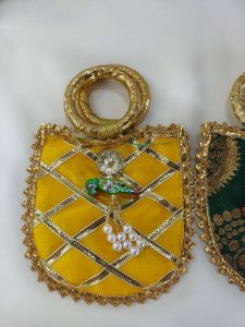 yellow wedding potli with gold lacework and parrot accents, ideal for weddings, bridesmaid gifts,