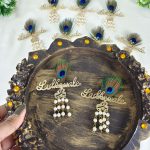 Featuring feather and delicate pearls, this brooch serves as a beautiful wedding favor or coat accessory. Perfect for groom side badges